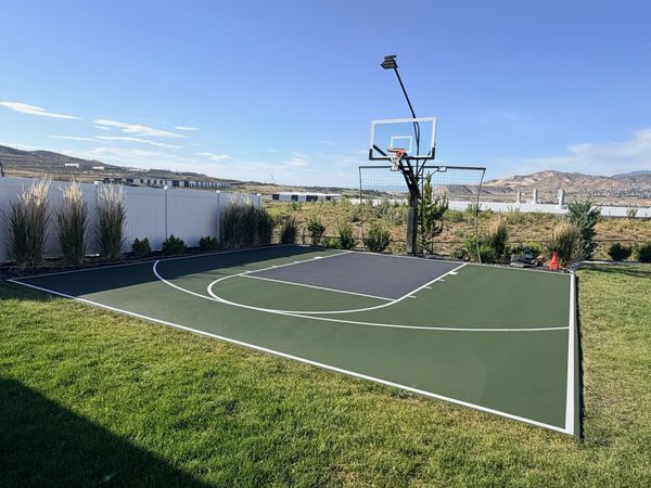 Green and Grey Backyard Basketball Half-Court with Mountain View by Precision Pro Courts
